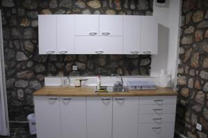 a kitchen with white cabinets and a sink at Villa Andrej Elshani in Ohrid
