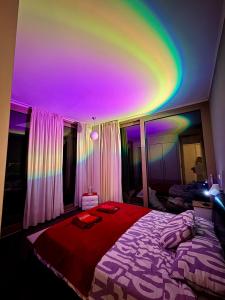 a room with a bed with a rainbow on the ceiling at Sea view Penthouse (YooBulgaria) in Obzor