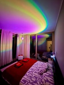 a room with a bed with a rainbow ceiling at Sea view Penthouse (YooBulgaria) in Obzor
