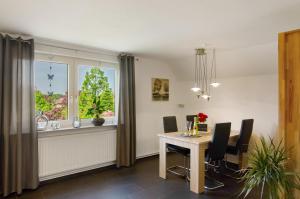 a dining room with a table and chairs and a window at Ferienwohnung Goesmann in Zetel