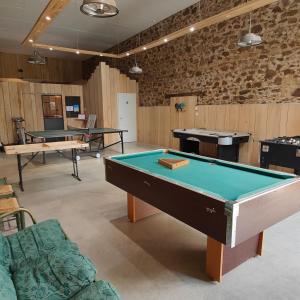 a room with a pool table and ping pong tables at La Libaudière in Pouzauges