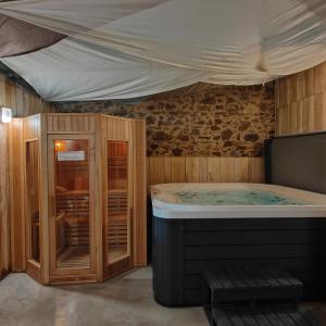 a jacuzzi tub in a wooden room with a ceiling at La Libaudière Hebergements Insolites et Chambres d Hotes in Pouzauges