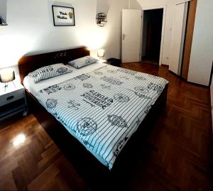 a bedroom with a bed with a white and blue blanket at Apartment Angelus in Zagreb