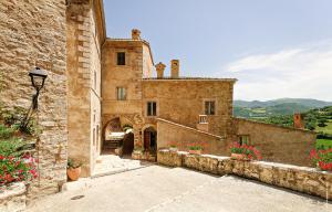 Castello Di Postignano Relais في Sellano: مبنى حجري قديم وامامه زهور