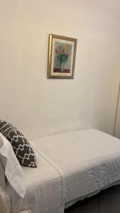 uma imagem pendurada numa parede acima de uma cama em La Terrazza Vercelli Bed & Charme em Vercelli