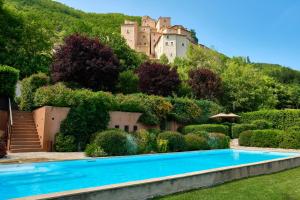um castelo no topo de uma colina com uma piscina em Castello Di Postignano Relais em Sellano