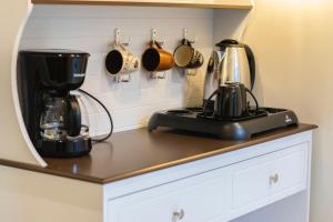 a kitchen counter with a coffee maker and pots and pans at شقق نرمادا المفروشة فرع قباء in Medina