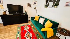 a living room with a green couch and a television at Salty Home’s in Peniche