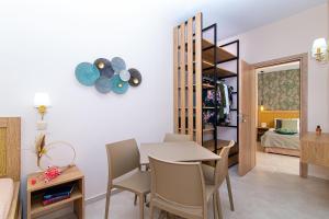 a dining room and living room with a table and chairs at Emerald Hotel in Malia