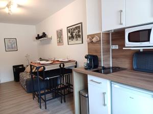 a small kitchen with a table and a microwave at Jacobin-centre ville-paisible-2 couchages in Amiens