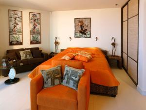a bedroom with an orange bed and a couch at Boutique Hotel Light House Jurmala in Jūrmala