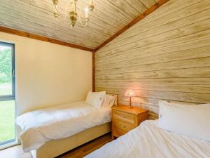 two beds in a room with wooden walls at 2 bed in Sherwood Forest 88428 
