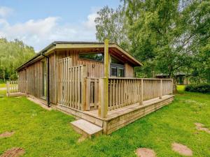 a wooden cabin with a porch in the grass at 2 bed in Sherwood Forest 88428 