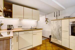 a kitchen with white cabinets and a sink at Ferienwohnung auf dem Ennerthof in Arnsberg