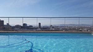 a large swimming pool with a view of a city at Four Seasons City Apartment ParkingPool Gym in Cape Town