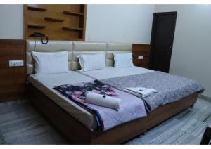 ein großes Bett mit zwei Handtüchern darüber in der Unterkunft Rk Lodge in Amritsar