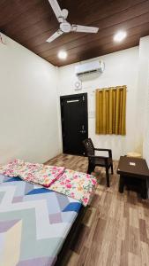 1 dormitorio con 1 cama, 1 silla y 1 mesa en Hotel Amrit shree, en Ujjain