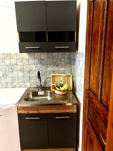 a kitchen with a sink and a basket of fruit at Hotel Paradise Ouranoupolis in Ouranoupoli