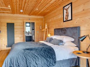 a bedroom with a bed in a log cabin at 3 Bed in Cullompton 94139 in Cullompton