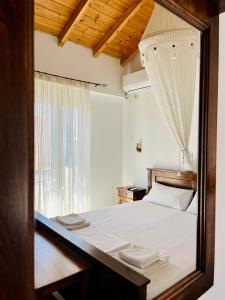 a bedroom with a white bed with a window at Avra Studios in Elafonisos