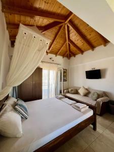 a bedroom with a large bed and a couch at Avra Studios in Elafonisos