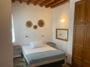 Dormitorio pequeño con cama y espejo en Cavo Lacia, en Gavrion