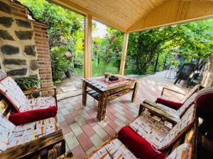 un porche cubierto con mesa y sillas en Guest house poligloti, en Telavi