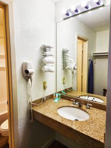 een badkamer met een wastafel en een spiegel bij Inn at the Waterpark in Galveston