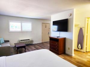 a bedroom with a bed and a tv and a couch at Inn at the Waterpark in Galveston
