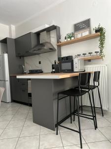 une cuisine avec un comptoir et deux tabourets à une table dans l'établissement Iris Apartment Nafpaktos, à Naupacte