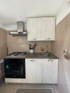 a kitchen with a stove and a sink at Blasu Home in Maratea