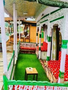 un porche con mesa y sillas rojas y verdes en N Group of Houseboat, en Srinagar