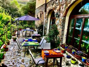 eine Außenterrasse mit Tischen, Stühlen und Topfpflanzen in der Unterkunft Le Petit Chateau in Vezzi Portio