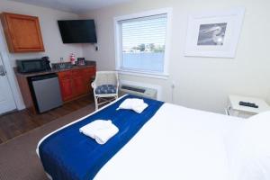 a bedroom with a bed with towels on it at Fin 'N Feather Waterside Inn by Kees Vacations in Nags Head