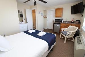 a bedroom with a large bed and a kitchen at Fin 'N Feather Waterside Inn by Kees Vacations in Nags Head