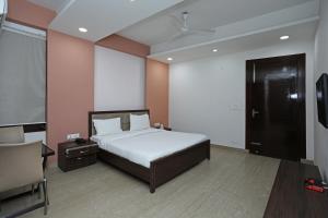 una camera con letto, scrivania e sedia di SPOT ON Hotel Sainik Inn a Nalmatha