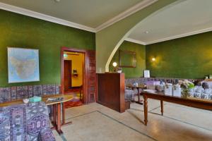 um quarto com paredes verdes e uma mesa e cadeiras em Astor Private Hotel em Hobart