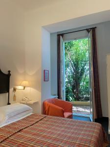 una camera d'albergo con un letto e una porta scorrevole in vetro di Hotel Beau Rivage ad Alassio