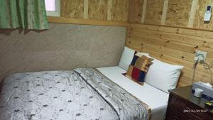 a bedroom with a bed and a wooden wall at 鑽石大旅社 in Pingtung City