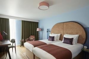 考文垂的住宿－Hotel Indigo Coventry, an IHG Hotel，酒店客房设有一张大床和一张书桌。