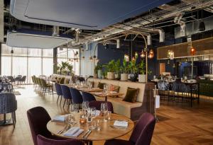 a restaurant with wooden tables and chairs and tablesearcher at Hotel Indigo Coventry, an IHG Hotel in Coventry