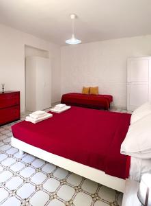 1 Schlafzimmer mit 2 Betten und roter Bettwäsche in der Unterkunft House On The sea Amalfi Coast in Vietri