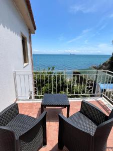 einen Balkon mit 2 Stühlen, einem Tisch und Meerblick in der Unterkunft House On The sea Amalfi Coast in Vietri