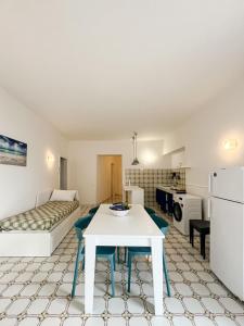ein Wohnzimmer mit einem weißen Tisch und eine Küche in der Unterkunft House On The sea Amalfi Coast in Vietri
