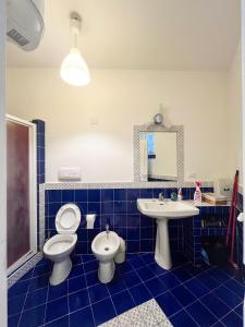 ein blau gefliestes Bad mit WC und Waschbecken in der Unterkunft House On The sea Amalfi Coast in Vietri