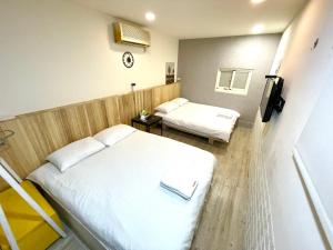 ein Hotelzimmer mit 2 Betten und einem TV in der Unterkunft Fengchia Aliproda in Taichung