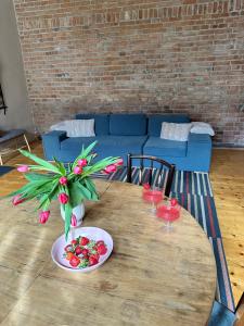 una mesa de madera con un bol de fruta y un jarrón de flores en World Studio Family Apartment, en Sibiu