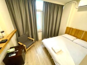 ein Hotelzimmer mit einem Bett und einem Stuhl in der Unterkunft Fengchia Aliproda in Taichung