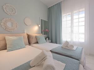 um quarto de hotel com duas camas e um sofá em Philippos Apartments em Acharavi