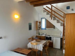 a small kitchen with a table and a staircase at Cavo Lacia in Gavrio